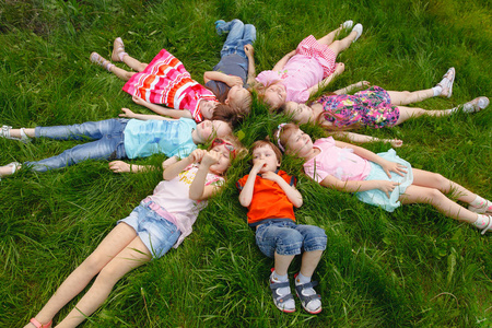 一群孩子在公园里的草地上玩耍和奔跑照片