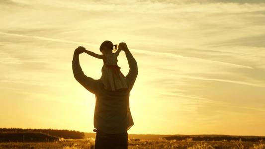 爸爸妈妈和女儿们在阳光下散步.孩子和父母度假旅行.