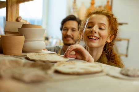 笑容可掬的女孩对不寻常的陶片感兴趣摄影图
