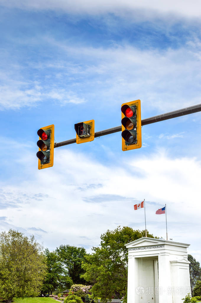 加拿大和美国国旗上的红色交通灯在温哥华附近的国际边界和平拱门纪念