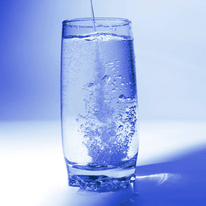 有气泡的水在透明玻璃中流动照片