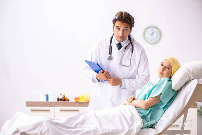 Young handsome doctor visiting female oncology patient 