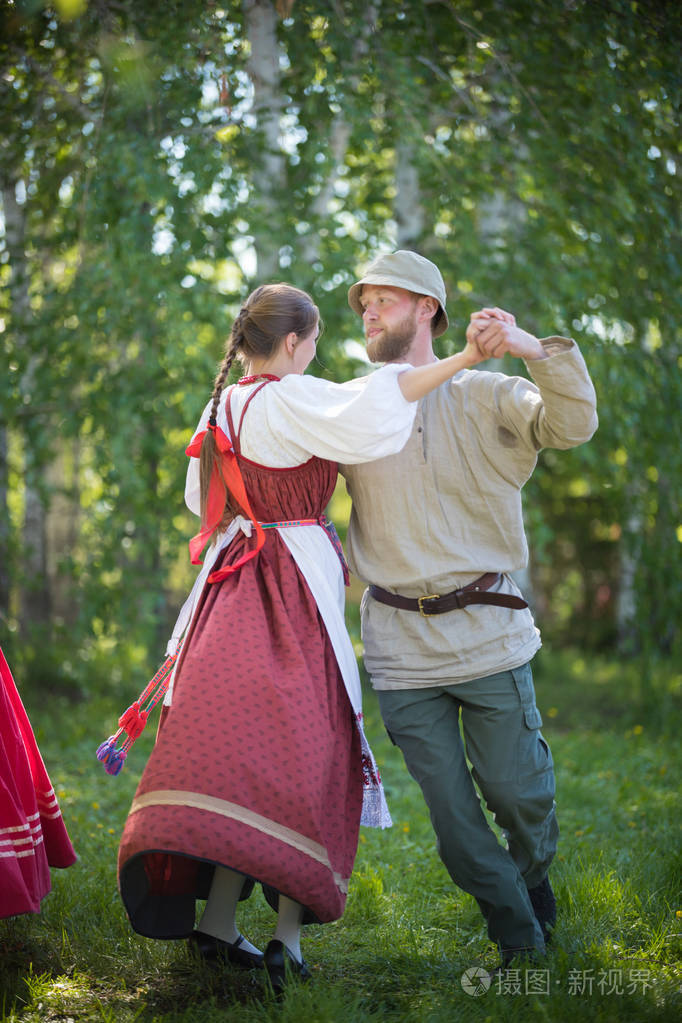 身着俄罗斯传统服装的男女正在表演俄罗斯民间舞蹈