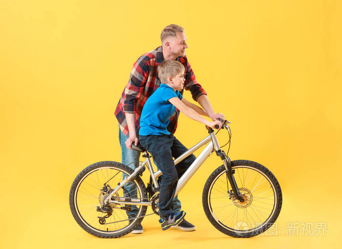 彩色背景的父子俩骑着自行车