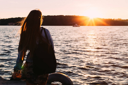 湖边女孩的背影.日落和船.c照片
