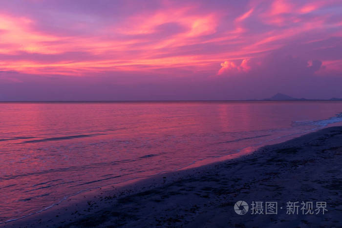 一个美丽的日落在一个海滩上泰国天空闪耀着紫色和蓝色的倒映在海洋中