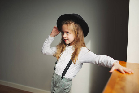 家里戴着黑帽子的可爱小女孩图片