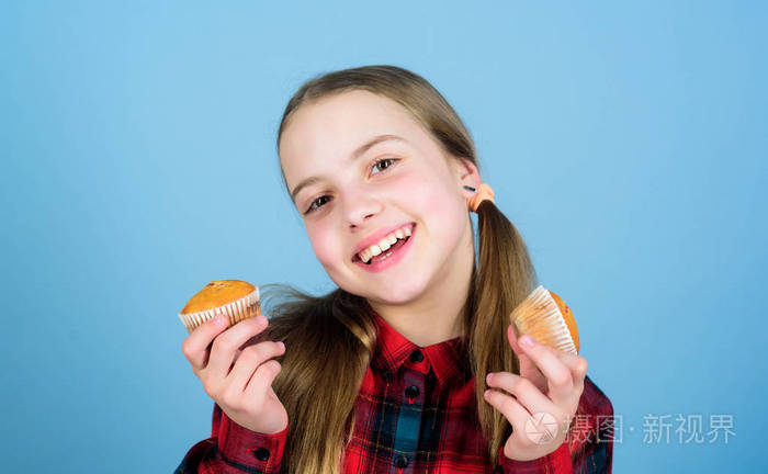 她太甜了所以食物味道很好小女孩笑着吃着刚烤好的甜点快乐的小孩拿着