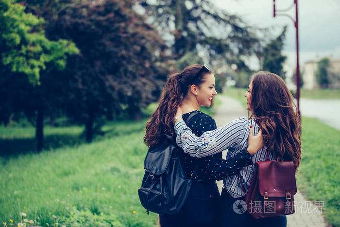 两位美丽的女性朋友在散步时互相拥抱