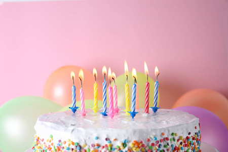 生日蛋糕,彩色背景上有燃烧的蜡烛和气球文本空间照片
