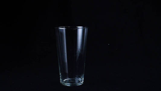 在黑色背景的透明玻璃杯中缓慢地播放着美味的奶昔和冰淇淋.框架.