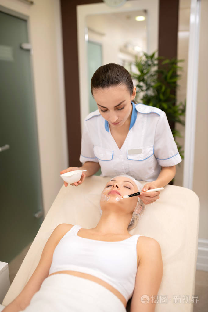 美容师穿着白色制服给客户戴口罩