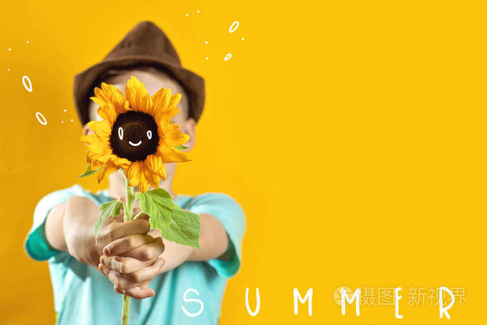 一个夏天的男孩穿着一件浅色t恤一朵黄色的向日葵遮住了他的脸
