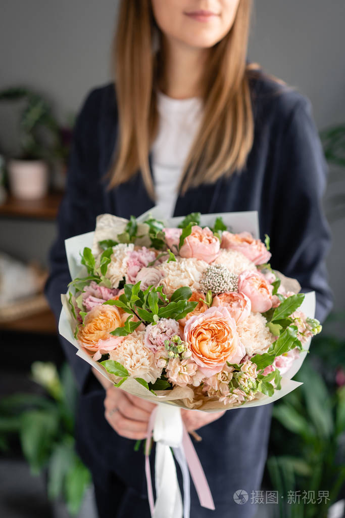 一束漂亮的混合花在女人手中花店概念美丽的鲜切花束送花