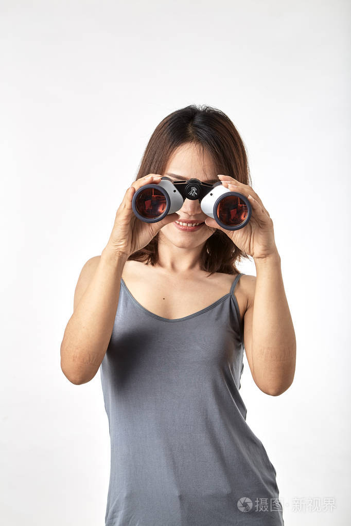 年轻的亚洲女人拿着双筒望远镜