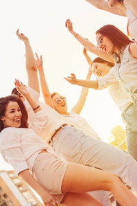 无虑的女朋友在城市街道停车场跳舞,在傍晚日落的背景下,夏日时光照片