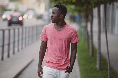 非洲裔美国人穿着活珊瑚色t恤在城市散步照片