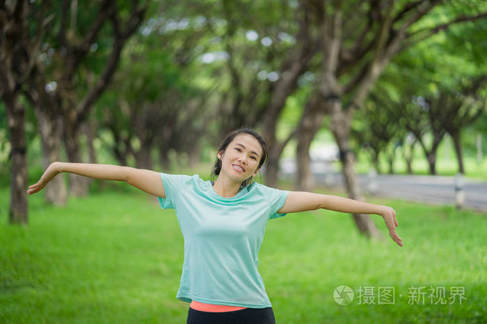 美丽的亚洲女人正在公园里锻炼。