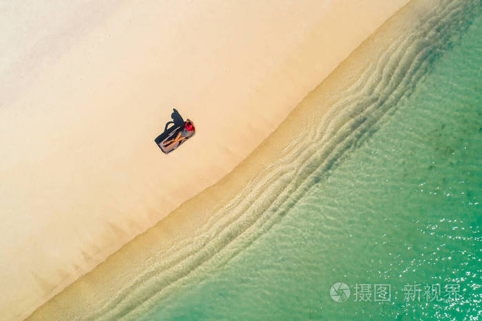 鸟瞰图苗条的女人躺在沙滩椅上晒太阳