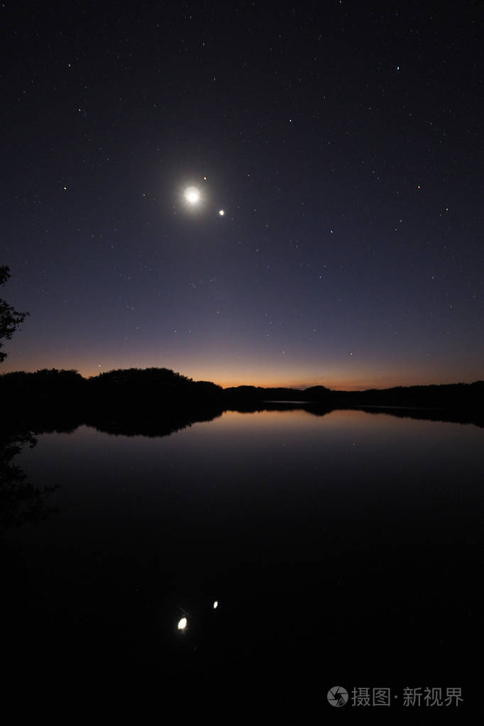 月亮和金星在沼泽地的波罗蒂斯池塘上空