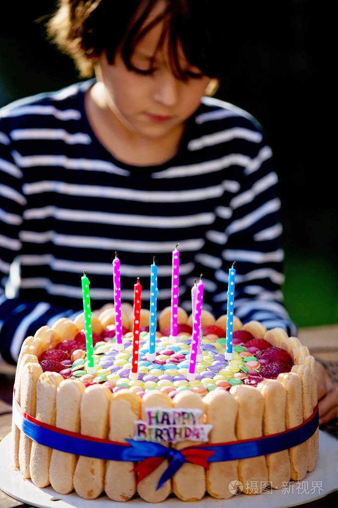 可爱的小男孩用五颜六色的蛋糕庆祝生日