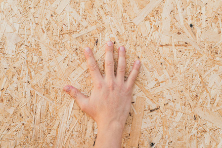 手指要压缩把锯末压在木板上.手放在压缩木屑板上.