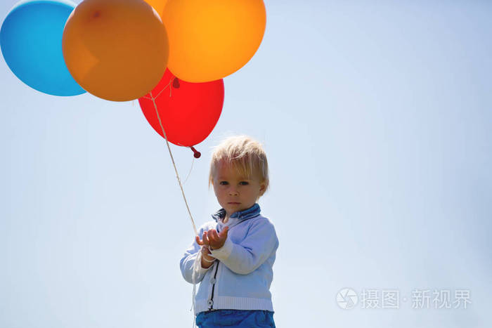 小男孩蹒跚学步的孩子在玩彩色气球
