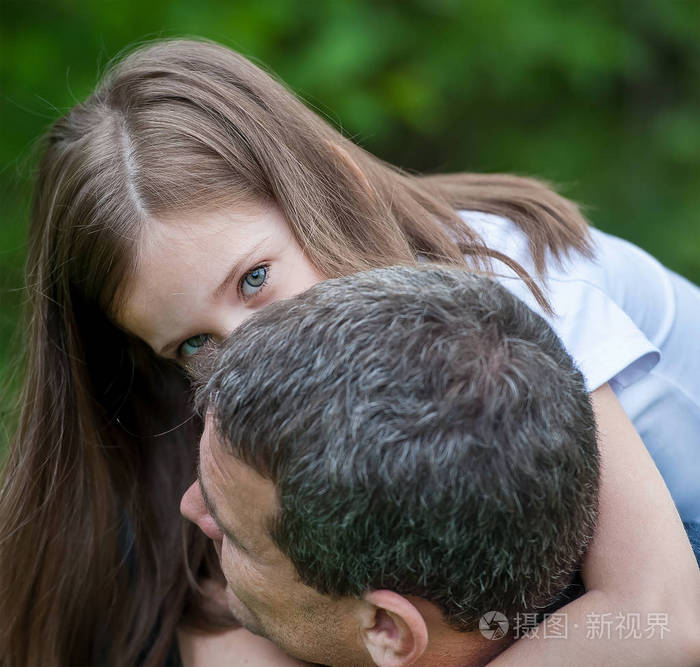 父亲怀抱的可爱小女孩的画像幸福的家庭父亲和女儿在玩耍拥抱可爱的