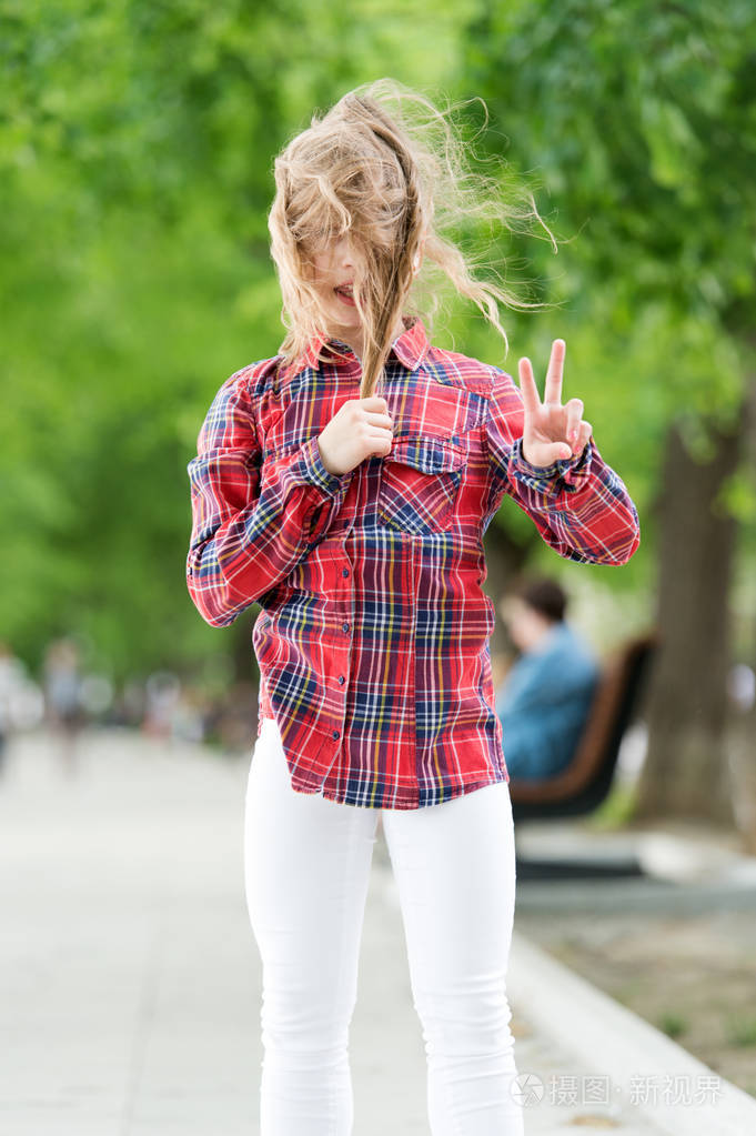 外面有风夏天头发凌乱的小孩可爱的孩子喜欢她的头发挥舞和显示胜利的