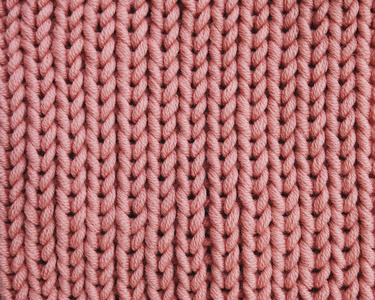 粉红色针织纹理为背景.美利奴纱线.活珊瑚色照片