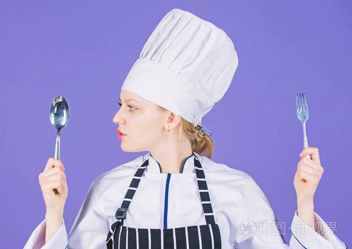 女厨师拿着餐具勺叉.胃口和味觉.传统美食.专业厨师和在家做饭.