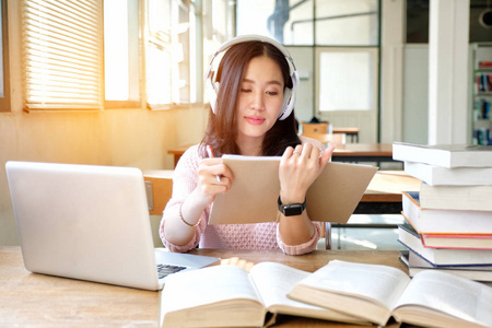 一个心情很好的年轻女子一边听音乐一边学习照片