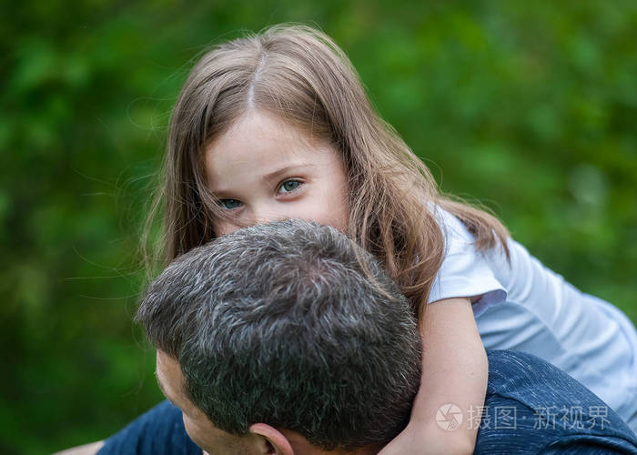 父亲怀抱的可爱小女孩的画像幸福的家庭父亲和女儿在