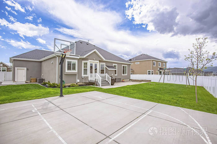 篮球场和秋千在一个单层家庭住宅宽敞的院子里