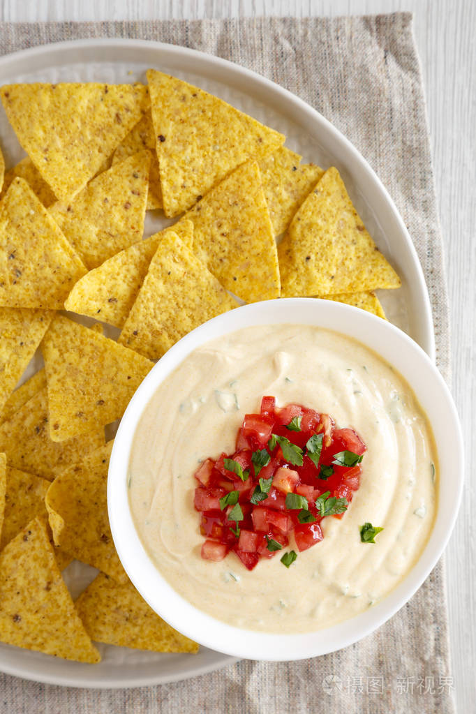 homemadecheesydipinabowlyellowtortillachipstopview