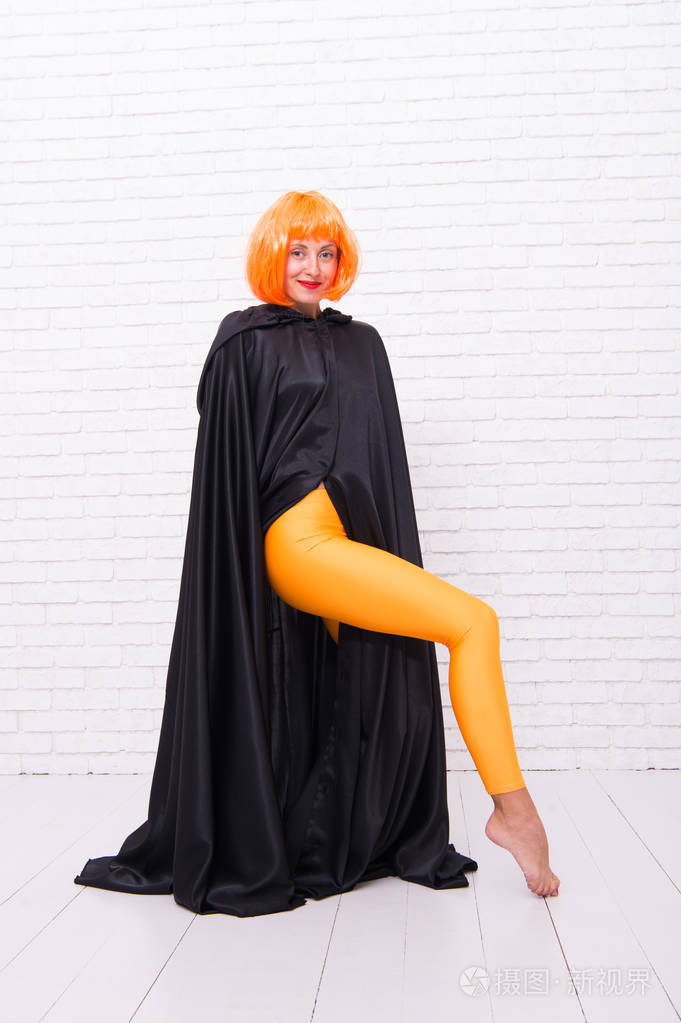 感受你的身体舞蹈演员披着斗篷跳舞穿着橙色紧身裤的修长腿女孩跳舞