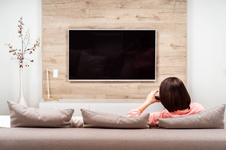 孤独被遗弃悲伤的女人独自喝酒看电视.酒精中毒与抑郁概念照片