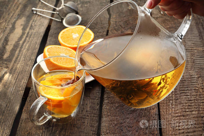 盛开的绿茶配橘子一杯热腾腾的芳香饮料