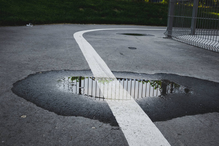 中间的条纹中间有水坑和白色条纹的柏油路.白色条纹表示标记照片