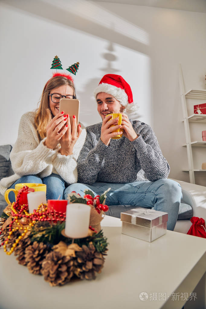 Happy couple enjoying New Years  Christmas eve with cellphone 