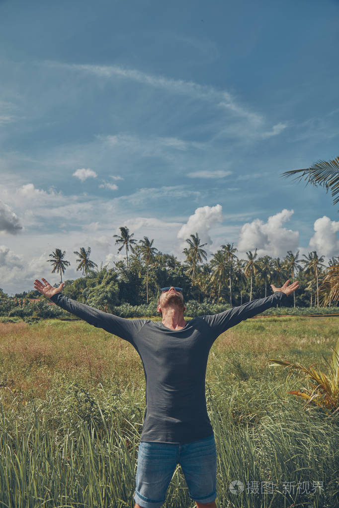 张开双臂享受热带气候的人