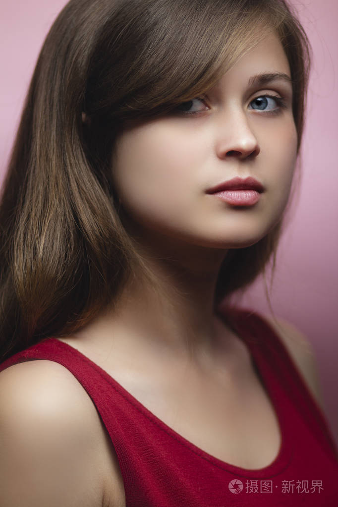 一个美丽的年轻女子在粉红色背景下的工作室肖像一个深金色头发的女孩