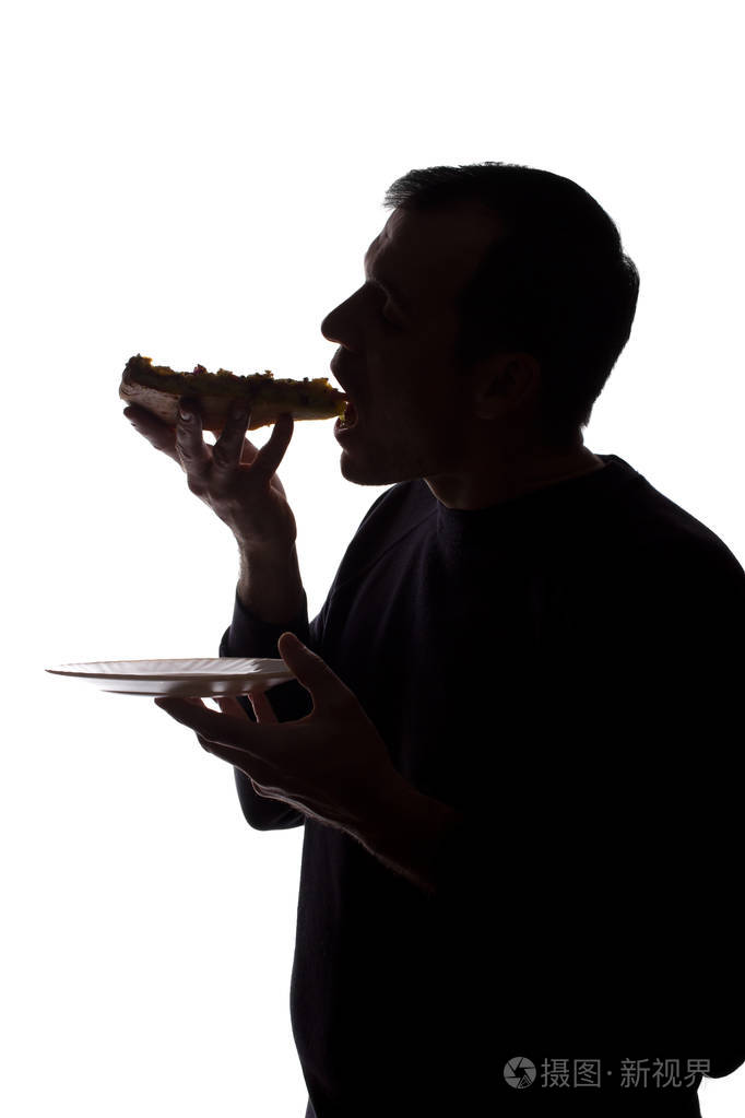 一个吃披萨的年轻人的肖像侧视剪影