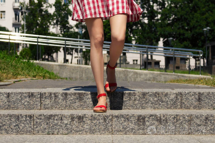 穿着凉鞋的女人在城市里走下楼梯