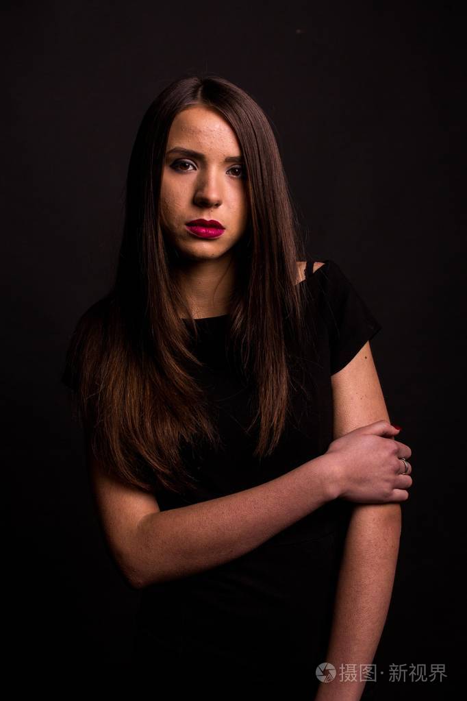 一位美丽的年轻女子的画像,身穿黑色连衣裙,妆容清凉,皮肤很好.