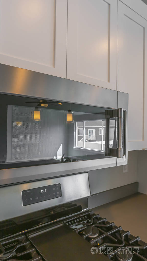 安装在厨房墙上的微波炉和木制橱柜的全景框架特写镜头