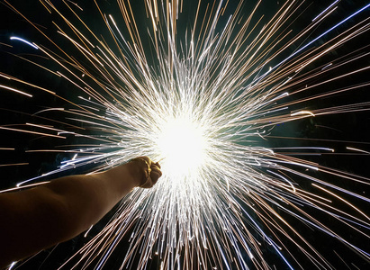 手摇花炮,一种在黑色背景下发出圆形火花的手工烟火照片