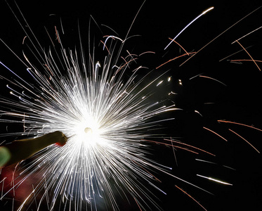 手摇花炮,一种在黑色背景下发出圆形火花的手工烟火照片