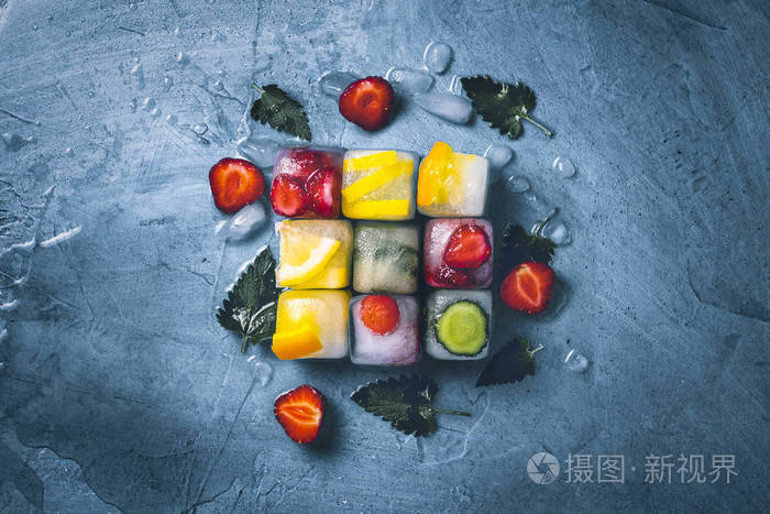 石头蓝色背景上有水果和碎冰的冰块