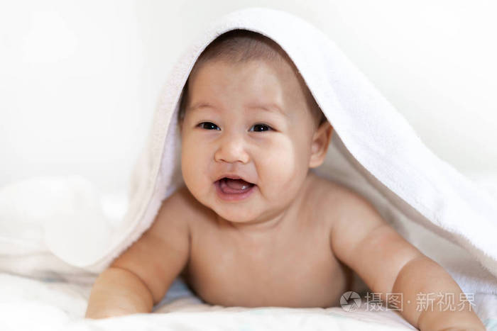 Portrait of happy smile baby relaxing under towel after bath on 